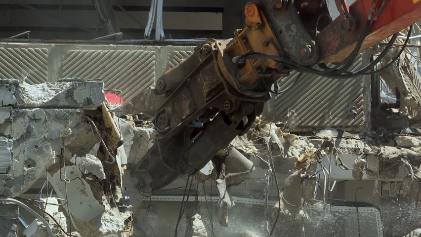 Building demolition excavator using Pulverizer Jaws to demolish a residential building