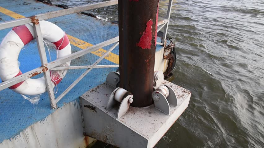 caster roller support of steel floating dock attached to iron pole move up and down with severe river waves, metal pier platform for passenger boat pick up and drop off commuter