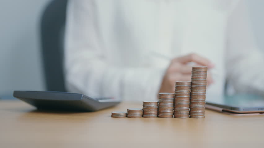 Money Saving for Future Plan, Retirement fund, Pension, Investment, Wealth Business and Financial concepts. Woman calculate and counting money coins on table