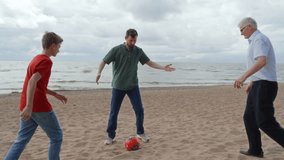 Active grandfather playing with teenager grandson and adult son football. - Powered by Shutterstock - Get 15% off with code: PIKWIZARD15