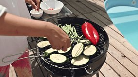 Grilling fresh vegetables including zucchini, red pepper, and green beans on a barbecue near the poolside during a sunny day for a healthy outdoor meal - Powered by Shutterstock - Get 15% off with code: PIKWIZARD15
