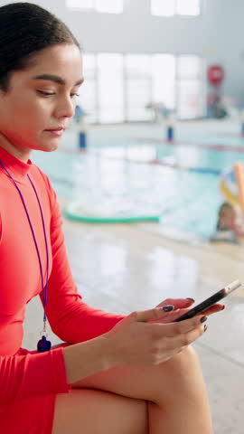 Coach, swimming pool and woman with smartphone, distracted or jeopardy with safety issue or risk. Lifeguard, water and children with instructor, scroll or notification with texting, caution or danger