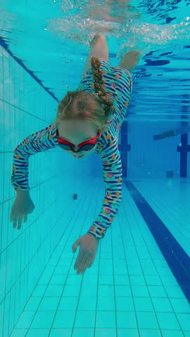 Swimming, underwater and wave with child in pool for wellness, learning and water sports. Happiness, summer and exercise with girl in aquatic center for education, development and competition