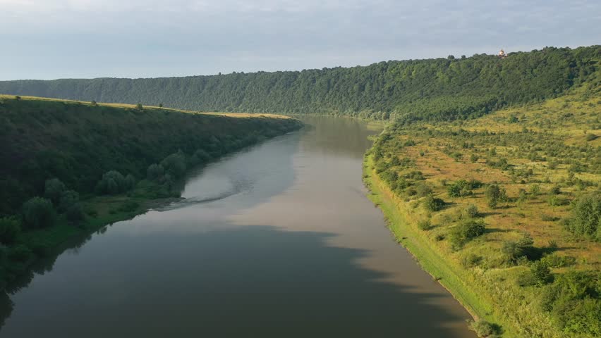 Drone footage of a majestic river flowing through hilly terrain. Location place Dniester Canyon, Ukraine, Europe. Bird