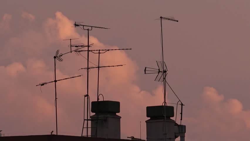 A silhouette of a television antenna on top of a building in Lisbon, Portugal