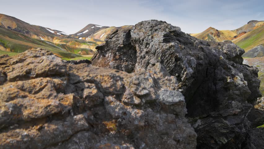 Brown rhyolite mountains and frozen lava, Landmannalaugar Nature Reserve, Iceland. Icelandic nature in the center of the island - park Landmannalaugar with lots of hiking trails. Gimbal shot, UHD