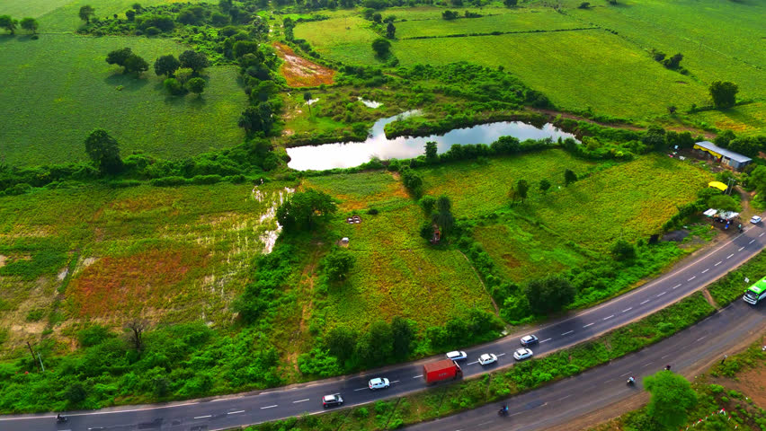 a beautiful lake amidst large land of agricultural farms area upper view