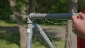 A close-up view of a soccer ball as it hits the net, scoring a goal, the goalkeeper's right hand is seen reaching for the ball, attempting to save it after it has already entered the net - Powered by Shutterstock - Get 15% off with code: PIKWIZARD15