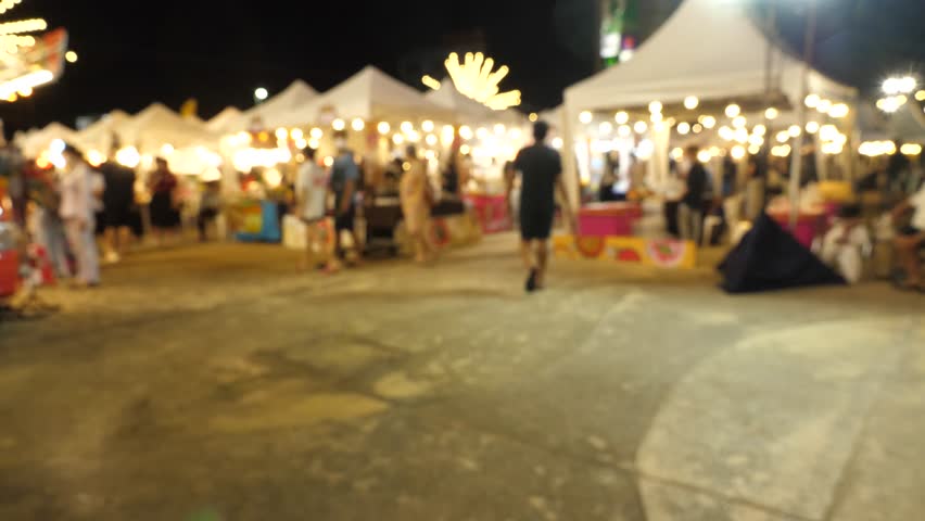 Blurred busy busy fresh market full with crowd people walking in street shopping.
Thailand street food night market booth festival light bright bokeh. Slow motion of video 4K.