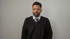 Judge in gown, young hispanic man standing on side pointing with natural finger and cheerful smile, upbeat expression over isolated white background - Powered by Shutterstock - Get 15% off with code: PIKWIZARD15