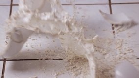 Breaking bowl of cereals with milk shattering to pieces, splashing on the kitchen floor, slow motion from 120 FPS - Powered by Shutterstock - Get 15% off with code: PIKWIZARD15