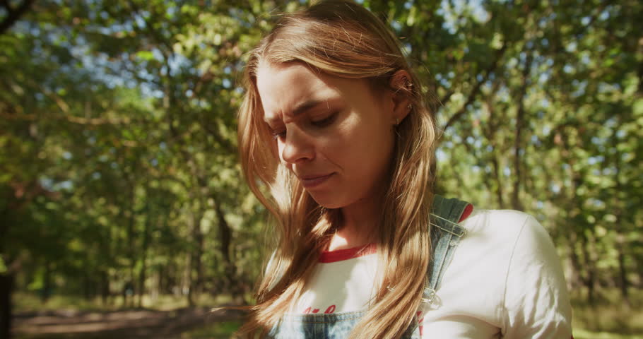 A young girl looks at her dirty clothes in horror and disgust