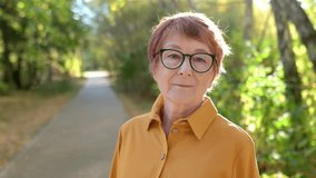 Portrait of a beautiful red-haired elderly woman while walking in an sunny autumn park. Senior active lifestyle, positive aging and longevity concept - Powered by Shutterstock - Get 15% off with code: PIKWIZARD15