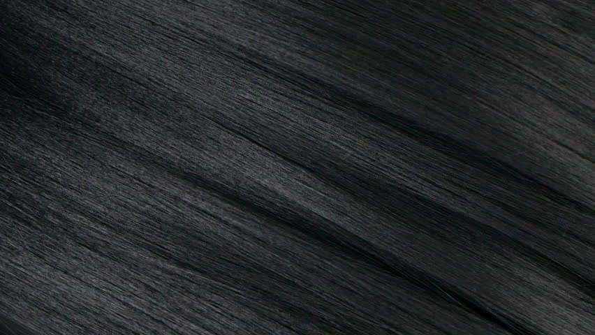 Closeup human long hair texture in slow motion, black straight hair background