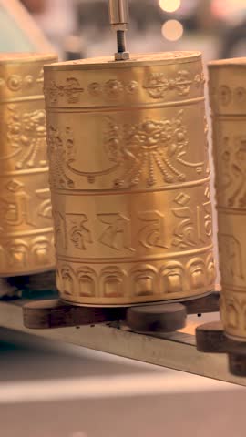 A sacred message is written on a spinning Prayer wheel with blurred background 