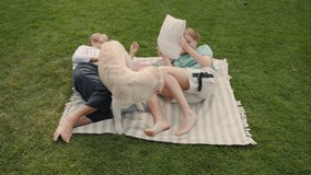 An elderly woman and her granddaughter relax on a blanket in the backyard, playing with their Golden Retriever and enjoying quality time together. - Powered by Shutterstock - Get 15% off with code: PIKWIZARD15