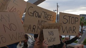 Group of activist people marching for world peace. Diverse demonstrators holding banners and posters protesting against war and violence. No war protest manifestation concept. - Powered by Shutterstock - Get 15% off with code: PIKWIZARD15
