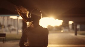 A young sporty woman runner is listening to music in earphones and training workout. Slim fitness girl is jogging outdoor. Concept of workouts running and healthy sport lifestyle - Powered by Shutterstock - Get 15% off with code: PIKWIZARD15