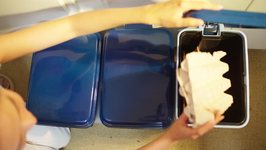 Asian woman put the trash into sorting bin in the kitchen at home. People separate household wet waste, plastic and paper garbage. Recycling rubbish, environmental conservation, eco friendly concept.