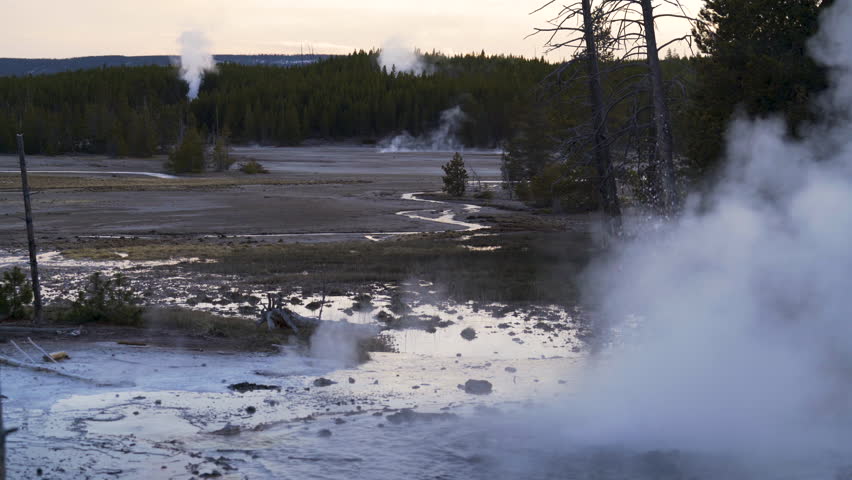 Cinematic shot of thermal pond at sunset at Norris Geyser Basin in Yellowstone National Park, USA