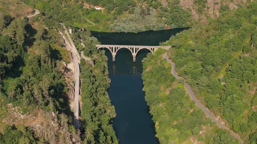 An aerial footage of a bridge crossing Sil River in Sil Canyon on a sunny day in Ribeira Sacra, Galicia, Spain