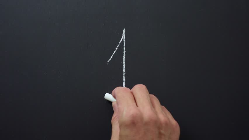 Hand writes the number 1 with white chalk on a black board