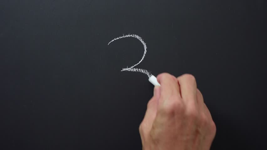 Hand writes the number 3 with white chalk on a black board