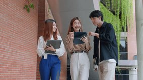 Attractive young Asian businessman and businesswoman talking as team discuss project outside office.Group of Asian employee walking outdoors in city. Corporate of modern colleagues concept - Powered by Shutterstock - Get 15% off with code: PIKWIZARD15