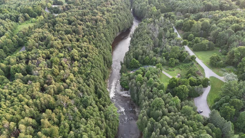 An aerial footage of the Grand River flowing in the scenic Elora Gorge at sunset in Elora town, Wellington County, Ontario, Canada
