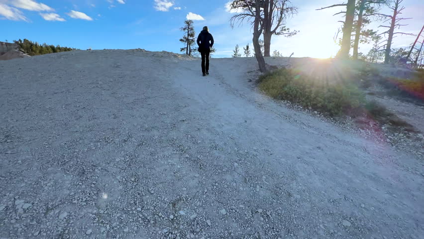 Motion tracking shot of female hiker walking in extreme outdoor adventure freedom Bryce Canyon Utah USA travel tourism