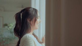 Happy young asian woman opening curtain at home, Smiling attractive lady looking outside apartment enjoying dreaming and contemplating feeling hope concept. - Powered by Shutterstock - Get 15% off with code: PIKWIZARD15