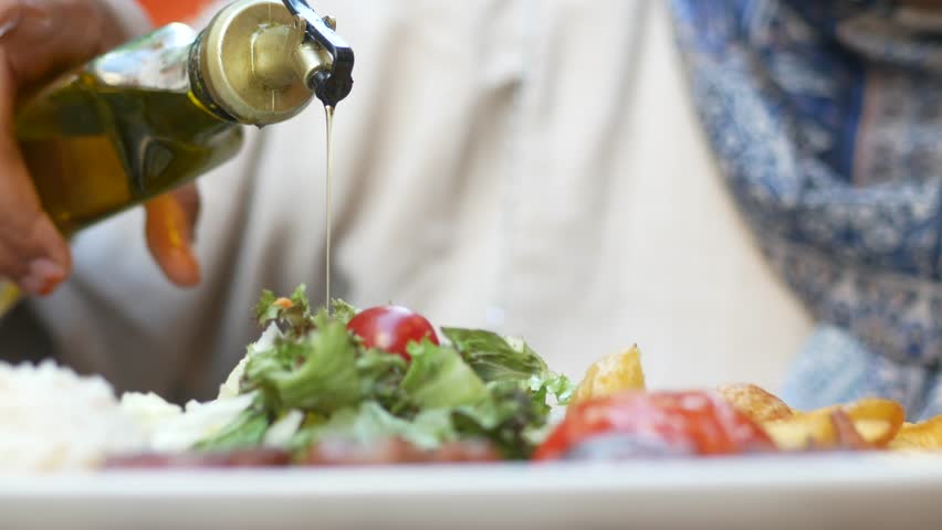 Healthy Salad Prep with Olive Oil in a Cozy Restaurant. Enjoy a fresh and wholesome meal