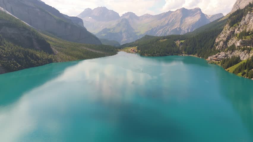 An aerial footage of the scenic Alpine Oeschinen Lake (Oeschinensee) on a sunny day in Kandersteg, Switzerland