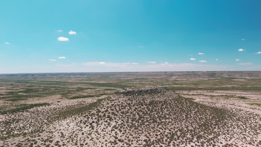 A drone view of a cliff in vast desert landscape, with blue sky background on a sunny day in El Paso, Texas