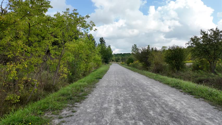 A footage of the Grand River Trail surrounded by lush greenery, under blue bright sky with white clouds in Ontario, Canada