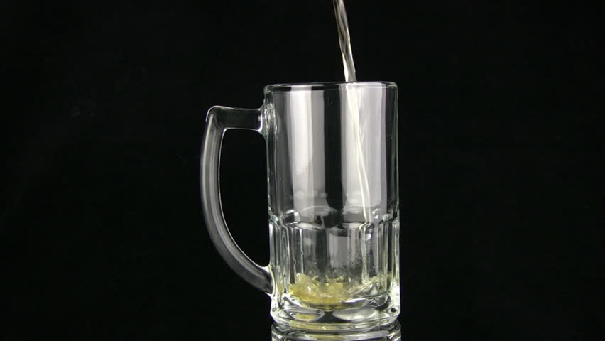 The beer by a jet is poured in a mug, the bubbles rise to a surface. A black