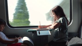 Children quietly focused on their drawing and writing as they sit side by side on a moving train, engaged in creative activities during a peaceful journey - Powered by Shutterstock - Get 15% off with code: PIKWIZARD15