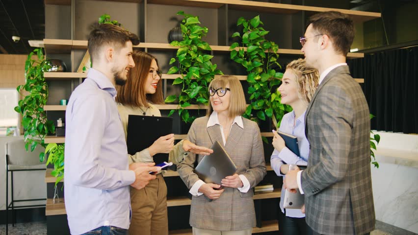 In a vibrant and modern office space, a diverse group of professionals is deeply engaged in a collaborative and dynamic discussion, sharing ideas