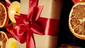 Close up of wrapped crafted christmas gift with red ribbon. Happy New Year 2025. Christmas background with gift box and green spruce branches. Vertical video - Powered by Shutterstock - Get 15% off with code: PIKWIZARD15