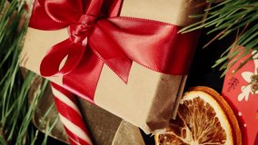 Wrapped with red ribbon gift box and christmas decorations rotating, close up. Table with christmas and new year decorations. Vertical video - Powered by Shutterstock - Get 15% off with code: PIKWIZARD15