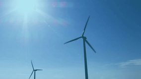 Wind turbines and financial data charts animation over blue sky background. Renewable energy, sustainability, investment, finance, environment, clean energy - Powered by Shutterstock - Get 15% off with code: PIKWIZARD15