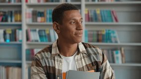 Happy African American man looking at camera toothy dental smile enjoyment student learner teacher library books bookstore bookcase male guy educate portrait graduate study university ethnic academic - Powered by Shutterstock - Get 15% off with code: PIKWIZARD15