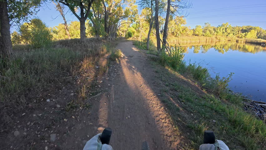 dirt trail along the Poudre River and ponds in Fort Collins, Colorado - POV from a touring gravel bike