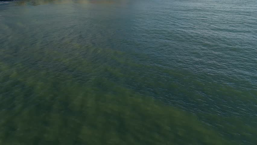 Opening establishing shot of picturesque coastal village overlooking from the sea