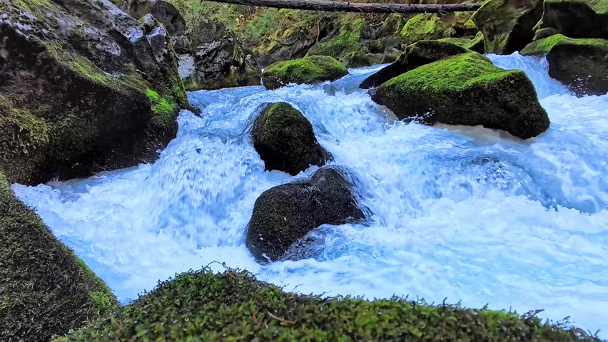 Clean river whitewater cascading over rocks in slow motion