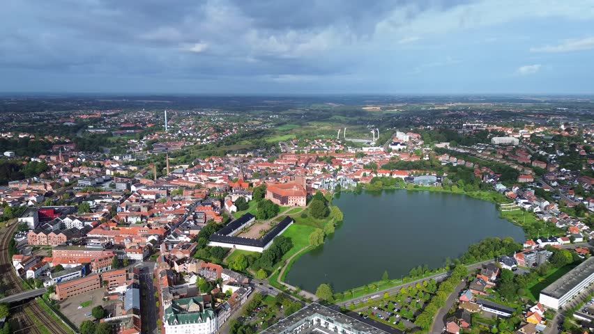 Aerial drone 4K film of Danish city of Kolding with and historic city with keep or castle near city center and lake