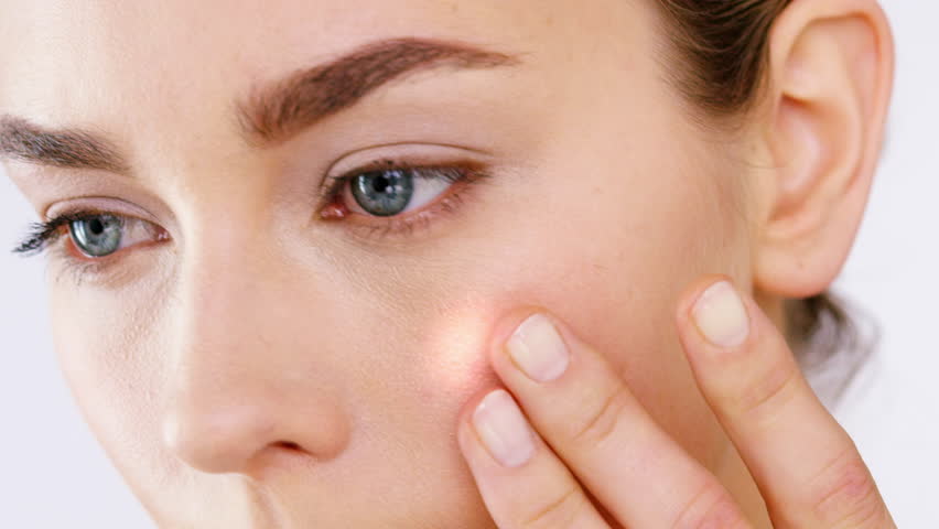 Woman, studio and touch face for skincare results with glow, light or moving for wellness by background. Model, person and hand with overlay, transformation and circle with benefits, health or change