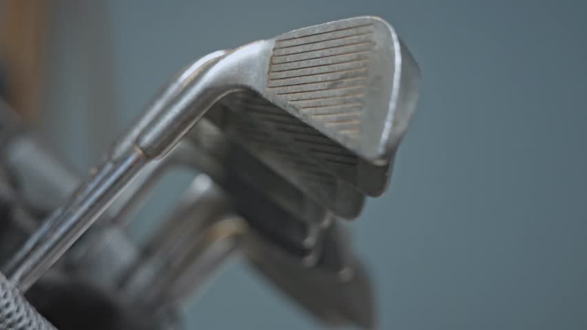 close-up shot of a used golf iron club being removed from a golf bag