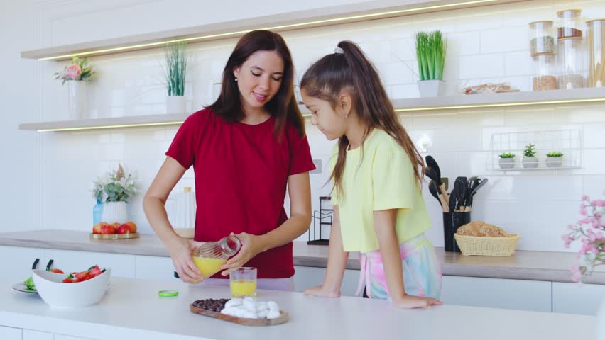 A Mother and Her Daughter Delight in Cooking Together in a Beautifully Bright Kitchen, Creating Memorable Moments and Strengthening Their Bond Through Joint Culinary Activities