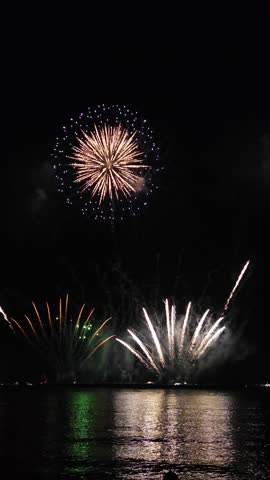 Golden big shiny fireworks with bokeh lights in the night sky. Glowing firework show. New Year's Eve fireworks celebration. Fireworks Festival - Footage from Pattaya Firework Festival in Thailand 